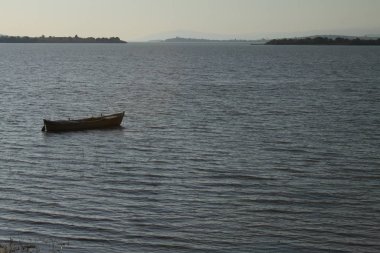 gün batımında gölde ahşap tekne.