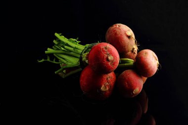 Büyük bir demet taze turp. Siyah arka plan. Üst görünüm