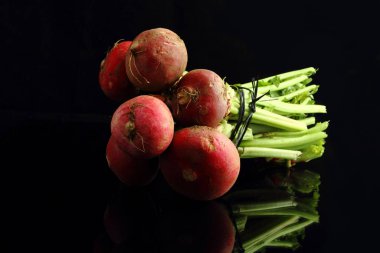 Büyük bir demet taze turp. Siyah arka plan. Üst görünüm