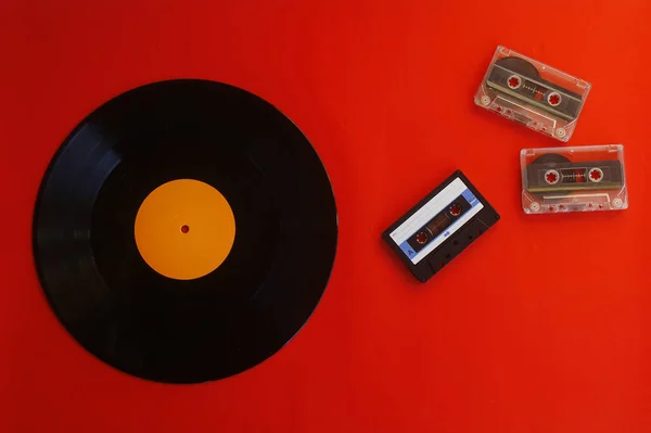Аудиокассета Виниловая Пластинка Красном Фоне Стиль Ретро Вид Сверху — стоковое фото