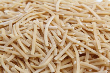 Bir arka plan dokusu olarak kuru pişmemiş erişte. Yakın çekim, üst görünüm