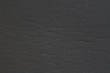 Arka planda deri dokusu olan siyah bir kağıt. El sanatları için iç ve dış dekorasyon veya arkaplan kağıdı