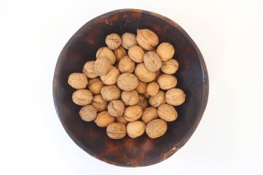 Beyaz arka planda izole edilmiş cevizler. Beyaz arka planda izole edilmiş ceviz yığını. Beyaz arka planda ahşap bir kasede ceviz. Metin için kopyalama alanı olan cevizler.