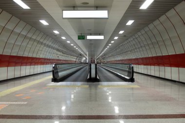 Metro istasyonunda yürüyen yürüyen merdiven. Reklamcılık, modelleme konsepti, düşük ışık hızı deklanşörü için metro ya da yeraltı koridorunda boş ilan panosu bulunan yürüyüş yolu