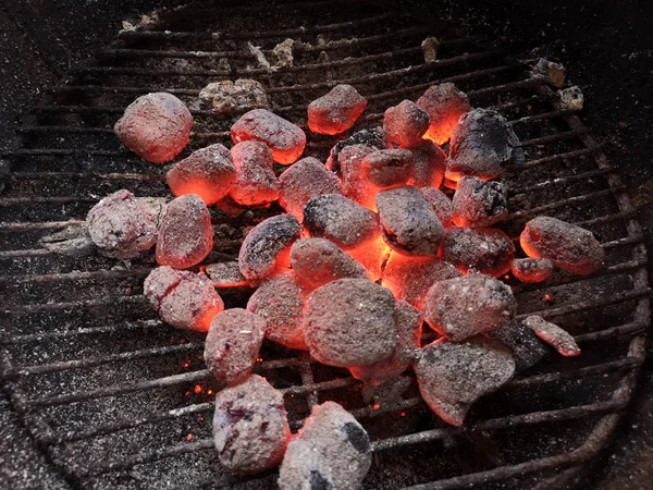 Close up glowing charcoal briquettes on grill grate — Stock Photo, Image