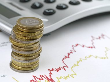 Arkaplanda hesap makinesi ve hisse senetlerine yatırım yoluyla mali büyüme konseptiyle ticaret grafiğine istiflenmiş avro sikkeleri