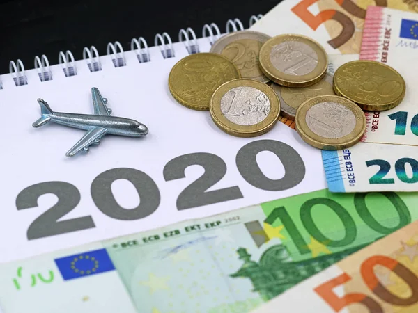 Airplane with euro banknotes and coins, money on calendar, concept of increasing air traffic in 2020 — Stock Photo, Image
