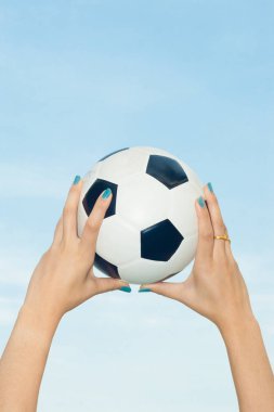 Bir futbol topu gökyüzüne doğru gidiyor kadın
