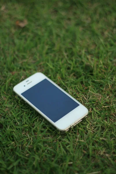 Yeşil çimenlerin üzerinde cep telefonu
