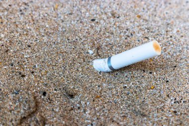 Sigara izmaritleri kum üzerinde kaldı, kum üzerinde sigara beyaz Butts,