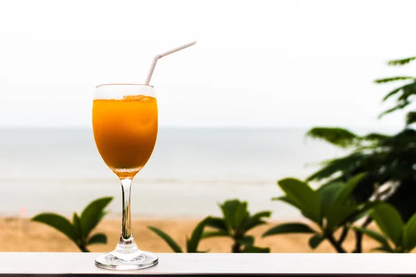 Vaso Zumo Naranja Con Fondo Hojas Verdes Playa Arena Fondo — Foto de Stock