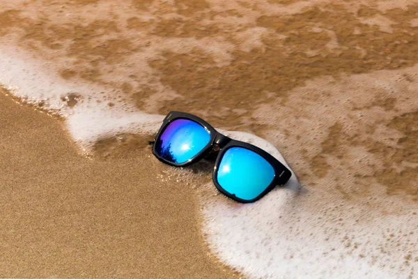 Sun glasses on the sand beach