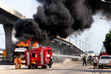 İtfaiyeci yanan büyük alevler ile kamyonun püskürtme ve 