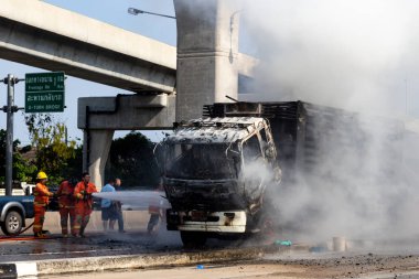 İtfaiyeci yanan büyük alevler ile kamyonun püskürtme ve 