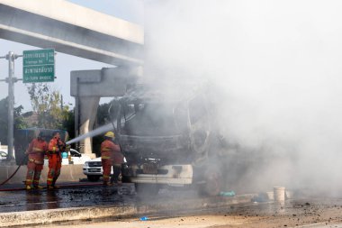 İtfaiyeci yanan büyük alevler ile kamyonun püskürtme ve 