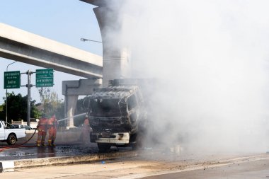 İtfaiyeci yanan büyük alevler ile kamyonun püskürtme ve 