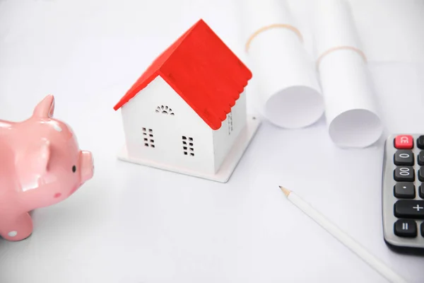 house model with piggy bank on tabl