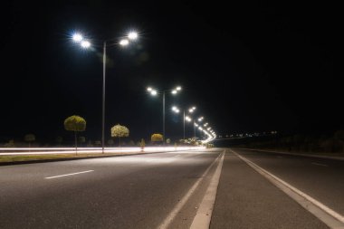 Boş asfalt yolu ve geceleri şehir manzarası