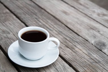 Kahverengi ahşap bir masada beyaz kahve fincanı