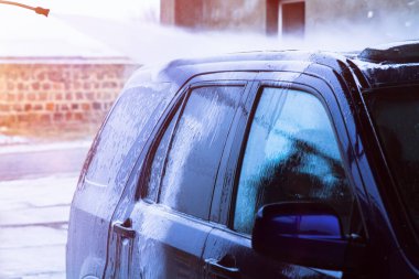 Açık havada yıkanan mavi araba.