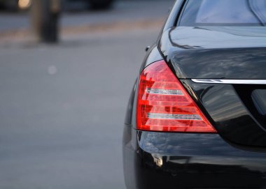 Bulanık siyah arka planda şehir arabasının arka ışığı