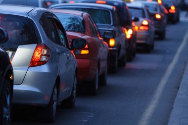 Bulanık yoğun yol, trafik ışıklarında bekleyen uzun arabalar.