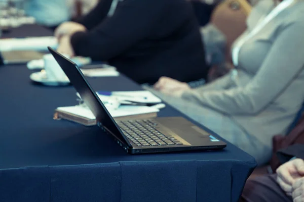 商人们带着笔记本电脑坐在研讨会上的近景 — 图库照片
