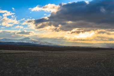 Gün batımında bulutların arasında çırpınan parlak güneş ışınları. 