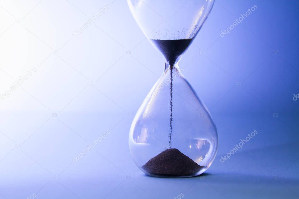 Sand running through an hourglass measuring passing time.