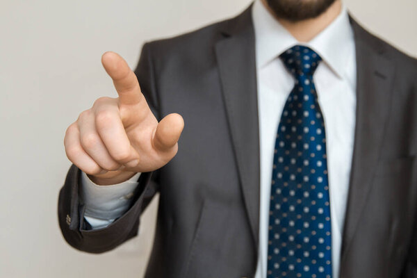 Hand of a businessman with raised index finger pointing out. 