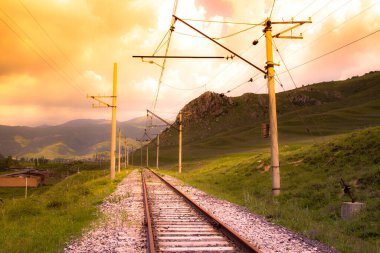 Gün batımında demiryolu ve elektrik hatları.