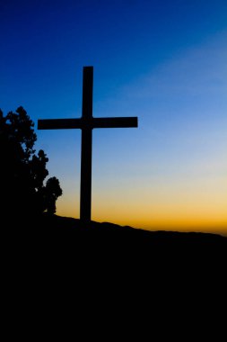Günbatımı arkaplanlı dini haç. 