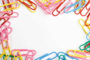 Beyaz arkaplanda renkli ataçlar.