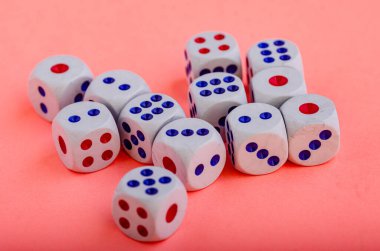 Pembe arka planda yumuşak ışıklandırmalı bir sürü zar var.