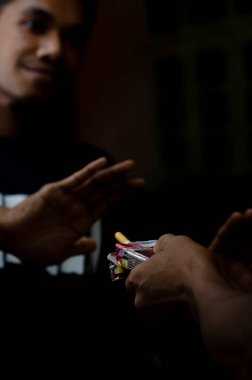 Bir adam başka bir adama sigara veriyor ve gösterişsiz bir el yazısıyla cevap veriyor.