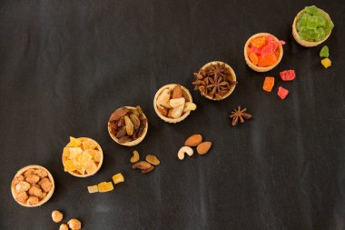 Kurutulmuş meyveler, fındık, baden, sırlı fındık gözleme bardak siyah bir zemin üzerine