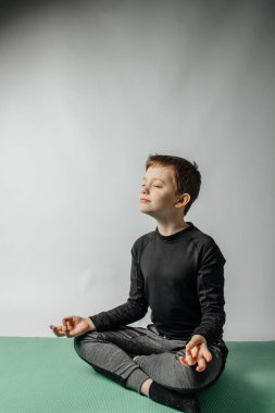 Çocuk yoga ve uygun nefes alma becerilerini öğreniyor..