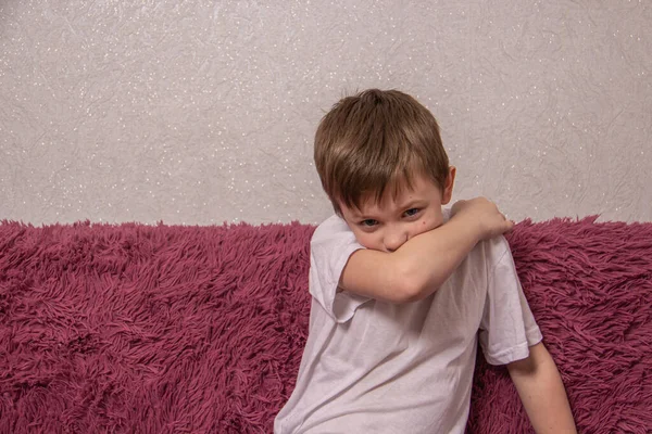 Мальчик правильно закрывает лицо локтем, когда чихает, чтобы не распространять вирус. — стоковое фото