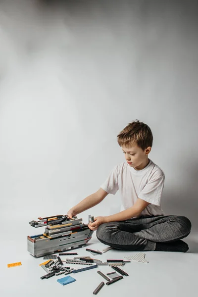 Der Junge Sammelt Einen Konstrukteur Aus Bunten Teilen — Stockfoto