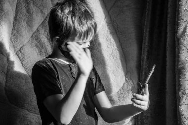 Çocuk evde tek başına oturuyor ve internet üzerinden akrabalarıyla veya arkadaşlarıyla iletişim kuruyor..