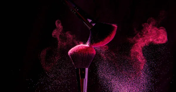 Cosmetic brushes in a bright palette of powder. Colorful explosion under makeup.