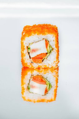 Güzel ve lezzetli bir suşi rulosu ayna masasında duruyor ve ona yansıyor..