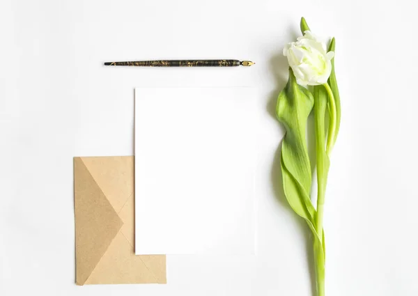 Літера, конверт і тюльпан на білому тлі. Листівка-запрошення, або любовний лист. Вид зверху, плоский ліжко — стокове фото