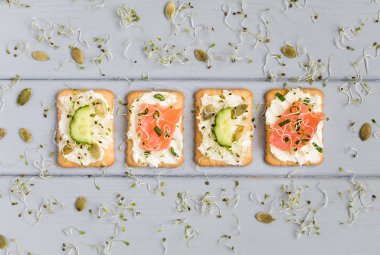 Krem peynir, sebze, Balık lezzetli kraker. Gri masada meze. Sağlıklı aperatifler, üstten görünüm, düz yatıyordu