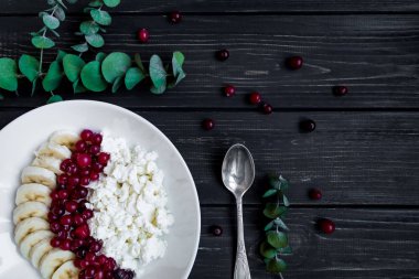 Kızılcık ve muz ile süzme peynir. Sağlıklı rustik kahvaltı kavramı. Düz yatıyordu, en iyi görünümü