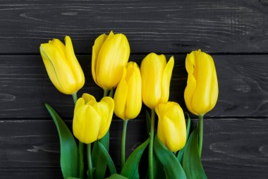 Sarı laleler siyah masada güzel buket. Üstten Görünüm, düz yatıyordu