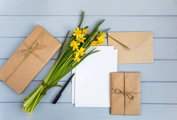 手紙、封筒、ギフト、灰色の背景に水仙。ロマンチックな休日の概念、平面図、平面レイアウト — ストック写真