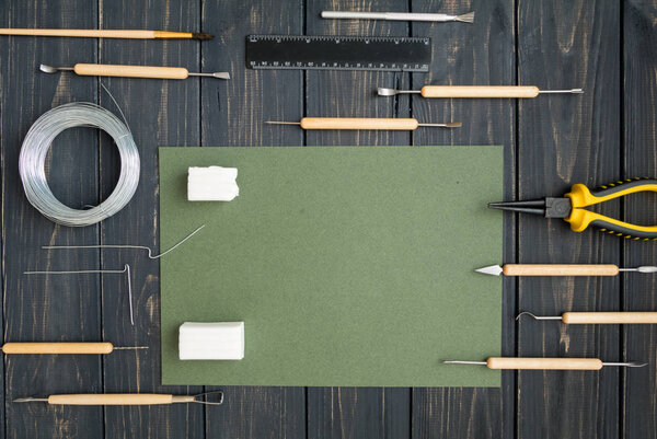 Craftsman workplace, ready for sculpturing from polymer clay. Vintage working table with molding tools. Flat lay, top view