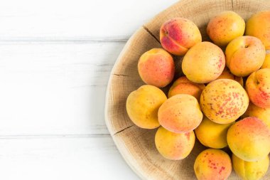 Beyaz ahşap masa üzerinde taze kayısı. Düz yatıyordu, en iyi görünümü