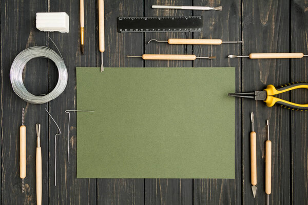 Craftsman workplace, ready for sculpturing from polymer clay. Vintage working table with molding tools. Flat lay, top view